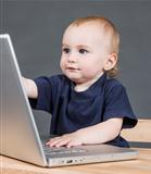 baby with laptop computer in grey background