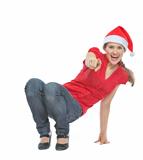 Happy woman in Christmas hat squatted on floor and pointing in camera