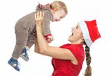 Mother in Santa's hat playing with baby