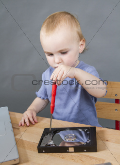 young child working at open hard drive