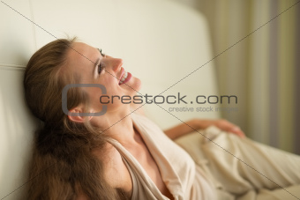 Portrait of laughing young woman laying on couch