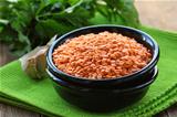 Bowl of red lentils on a wooden table
