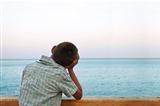 boy looking at sea in the sunset