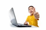 young boy in yellow t-shirt with laptop showing thumbs up at cam