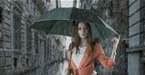 beautiful woman with umbrella in town under rain