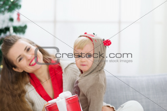 Happy young mother and baby spending Christmas time together