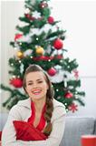Portrait of smiling young woman near Christmas tree