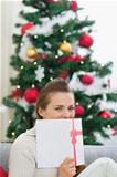 Female hiding behind Christmas postcard
