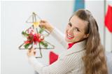 Smiling woman holding Christmas decoration tree