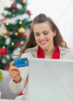 Happy young woman making Christmas shopping on internet