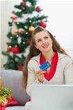 Woman with credit card thinking about Christmas presents