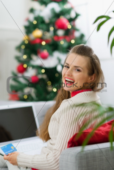 Happy young woman making online Christmas purchases