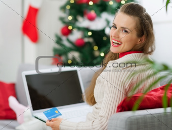 Smiling young woman making Christmas shopping on internet