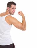Happy male athlete showing biceps