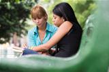 college students studying on textbook in park