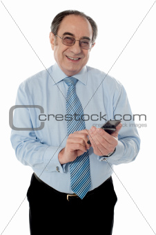 Smiling elder business executive texting