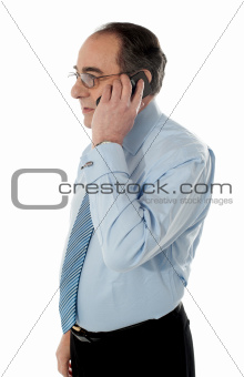 Side view of a senior manager attending phone call