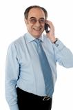 Smiling businessman attending phone call