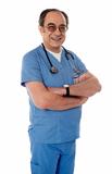 Smiling matured doctor posing with folded arms