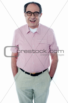 Smiling casual senior man with hands in pocket