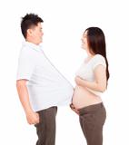 pregnant woman and man with football under shirt