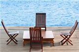 Wooden area with chairs and table on water