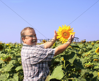 Cheerful farmer with sunflower