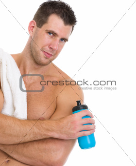 Portrait of healthy muscular man with towel and water of bottle