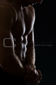 Closeup on man showing muscular body on black