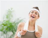 Portrait of laughing woman in sportswear with towel