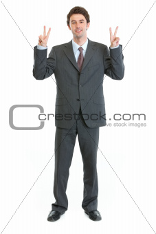 Full length portrait of businessman showing peace gesture