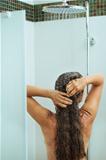 Long hair woman taking shower. Rear view