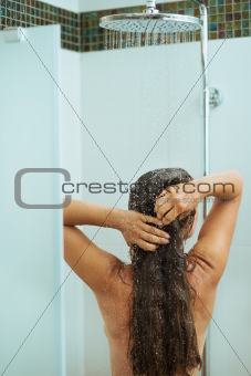Long hair woman taking shower. Rear view