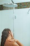Long hair woman taking shower under water jet. Rear view