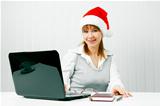 girl in a Christmas hat with a laptop
