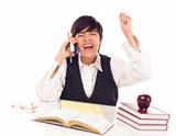 Excited Mixed Race Female Student at Desk with Books on Cell Phone Cheers Isolated on a White Background.