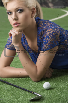 sexy blonde girl pays golf with hand under the chin