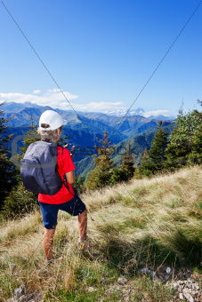 Young boy standing along a mountain path using a  smartphone