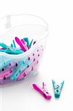 coloured plastic clothes pegs and basket
