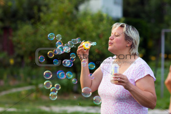 Woman blowing bubbles outdoors