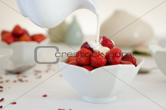 Cream Pouring From a Jug Over Fresh Strawberries