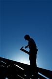 Worker on the roof structure in backlight