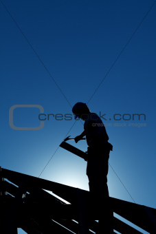 Worker on the roof structure in backlight