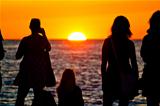 Women silhouette watching sunset on sea coast