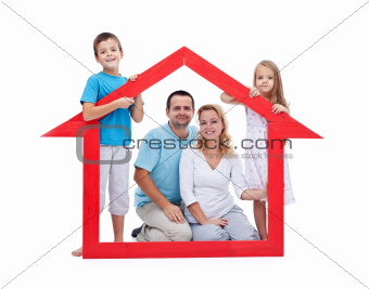 Young family with two kids holding house sign