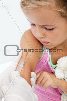 Worried little girl getting an injection or vaccine