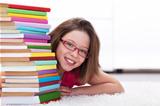 Young student with lots of books smiling