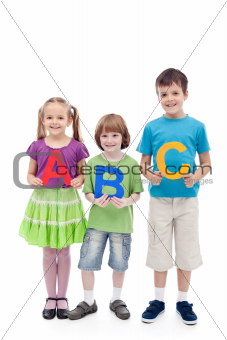 Happy school kids holding large abc letters