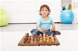 Little toddler boy with chess board