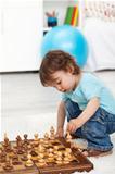 Toddler boy playing with chess pieces